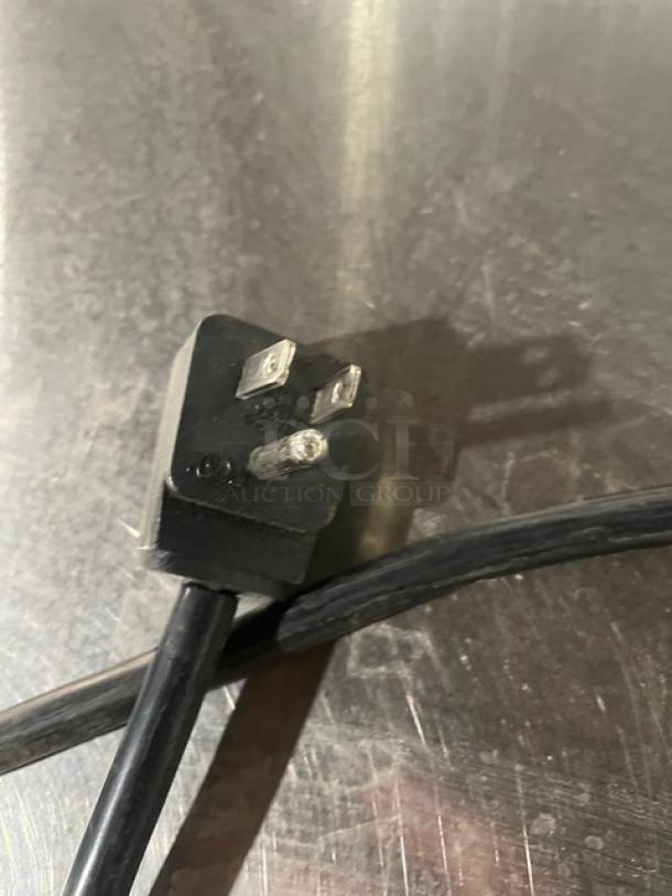 Close-up of power plug for Everest ETBR3 3-Door Undercounter Refrigerator. Black cable against stainless steel background.