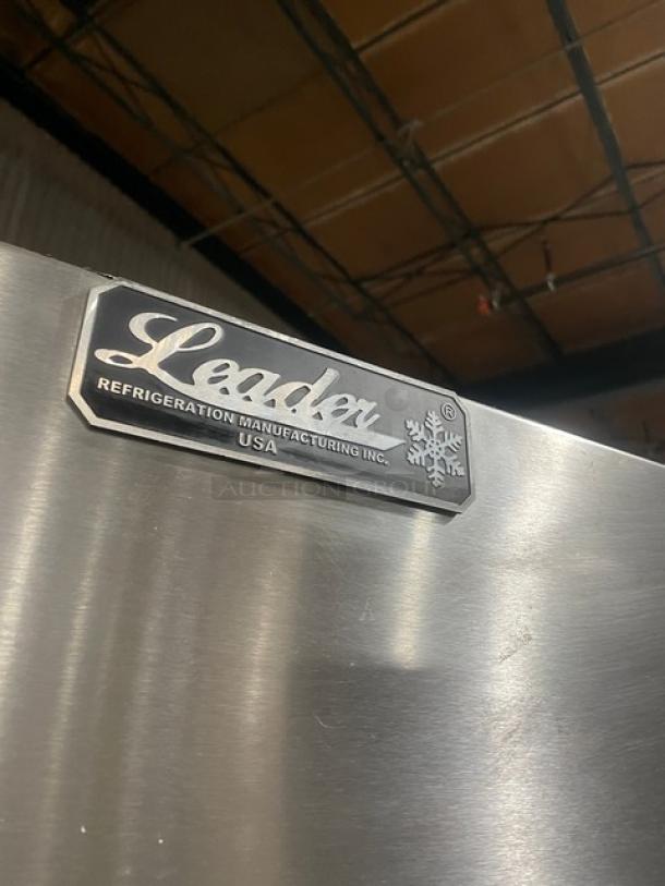 Leader stainless steel multi-tier refrigerated display case with straight glass, adjustable poly-coated wire rack, and rear sliding glass doors on casters.