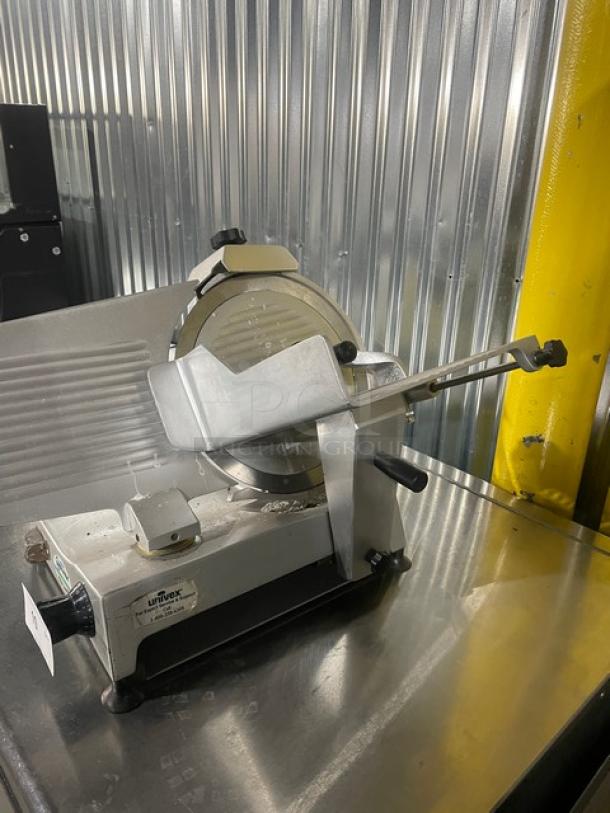 Univex commercial electric meat deli slicer, countertop model with legs. Features stainless steel blade and durable construction.