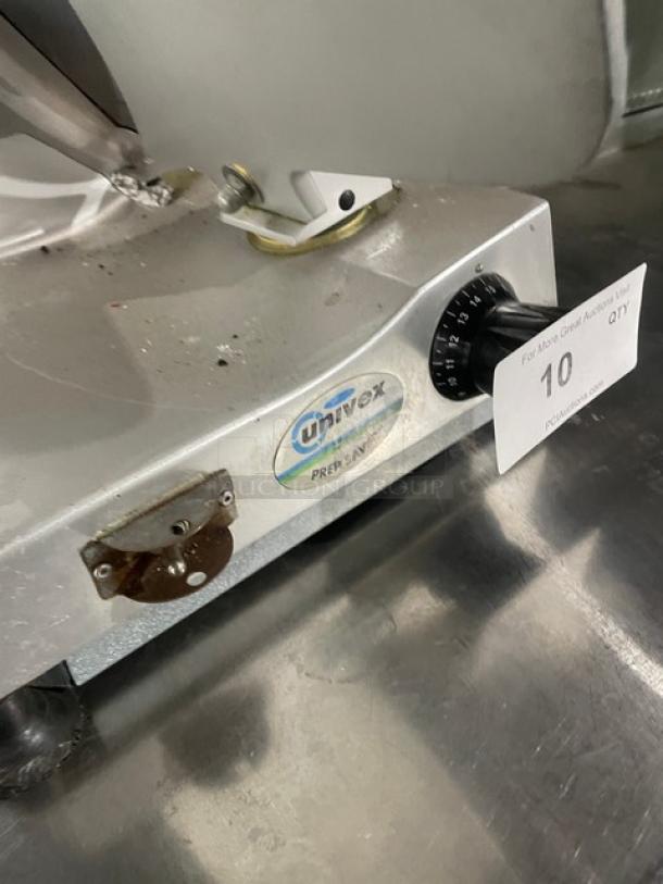 Univex commercial electric meat deli slicer on legs, visible Univex logo, adjustable knob, metallic finish, countertop model.