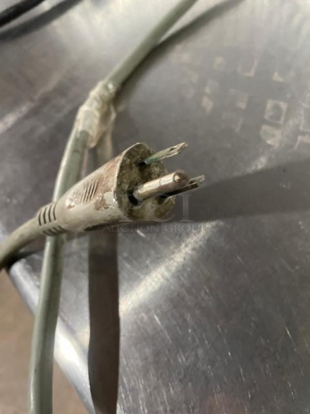 Univex electric meat deli slicer plug with visible wear, set on a metal surface. Ideal for commercial use.