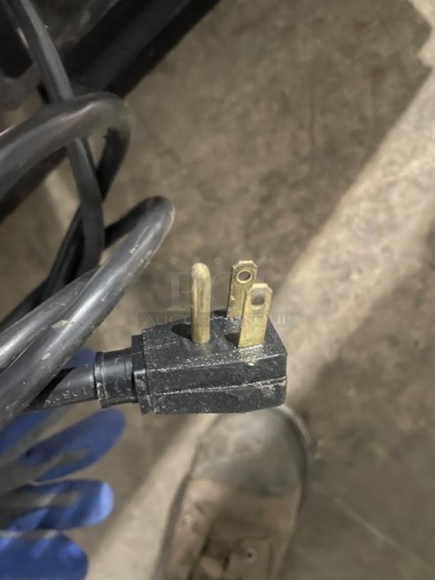 Close-up of the power plug for a True T-49F commercial stainless steel solid 2 door reach-in freezer.