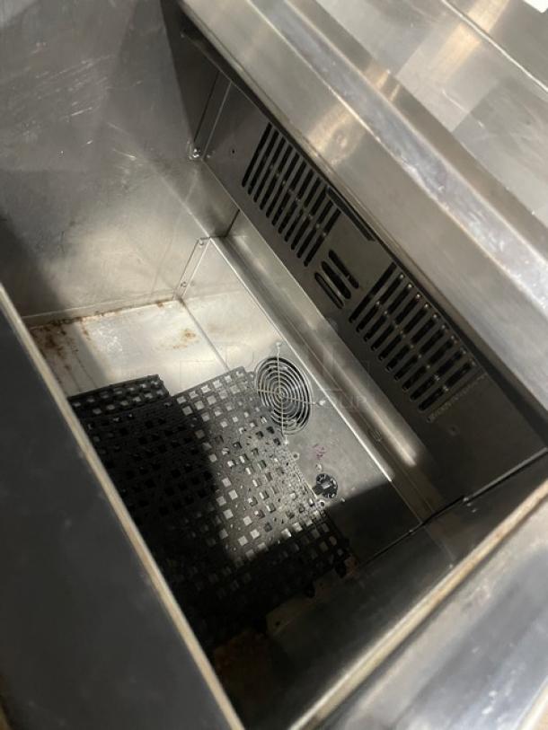 Stainless steel commercial bottle/glass chiller, interior view showing cooling vent and drain grid. Excellent condition.