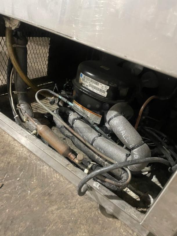 Commercial stainless steel bottle/glass chiller interior, showing cooling components and wiring in used condition.