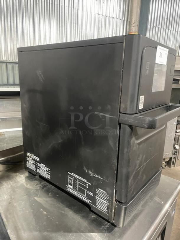 MerryChef commercial black electric countertop high-speed oven. Visible wear, model labels on side. Late model unit.