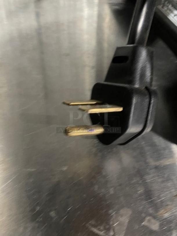 Black electric plug of MerryChef rapid cook oven on stainless steel surface.