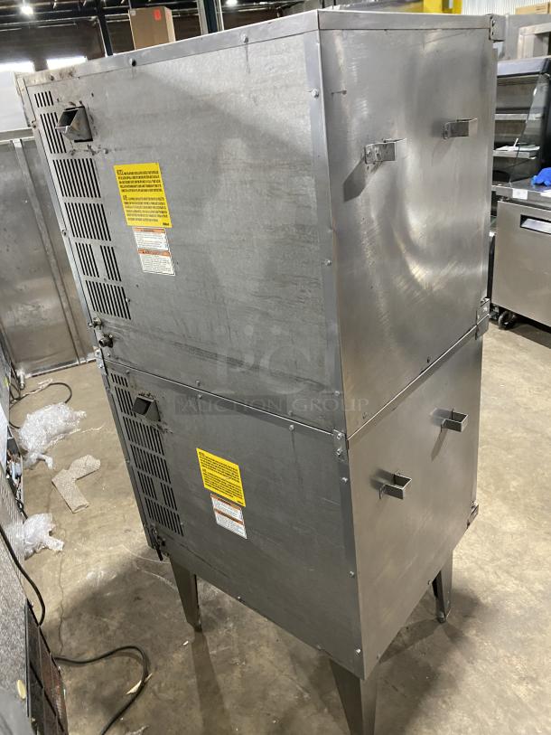 Vulcan commercial stainless steel gas-powered double-stacked convection oven with wired rack, on legs, visible safety labels.