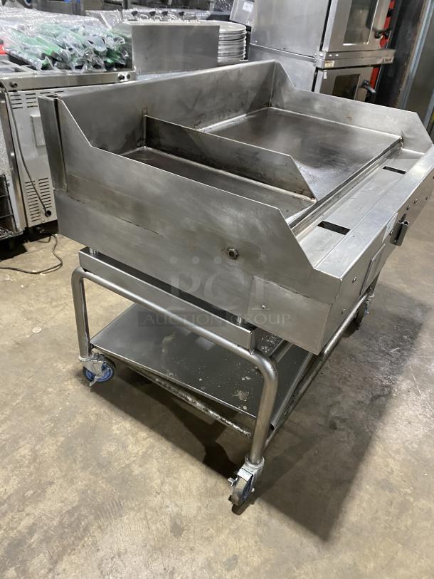 WoodStone stainless steel natural gas countertop plancha griddle with back and side splash, on welded stand with casters.