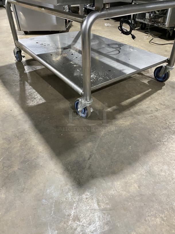 WoodStone stainless steel natural gas countertop plancha griddle with back and side splash on welded stand with casters.