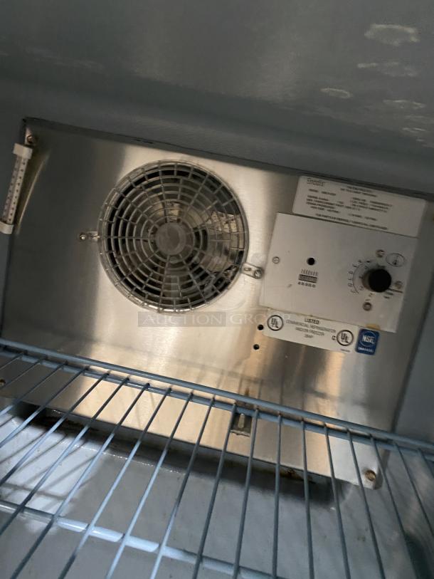 Delfield Model 406CADD1 stainless steel undercounter refrigerator, poly-coated wire racks, 115V, on casters, inside view.