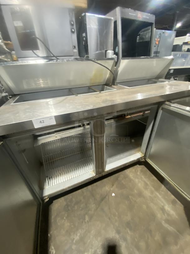 Continental 3-door stainless steel prep table, model SW72-18, with polly coated wired rack. On casters. Good condition.