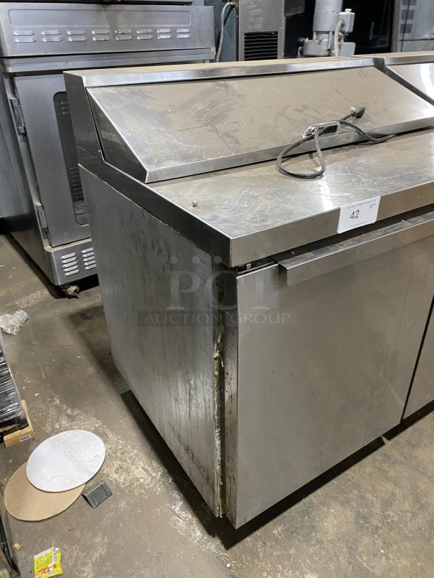 Continental SW7218 stainless steel 3-door refrigerated prep table, bain marie style, on casters, with visible wear and some damage.
