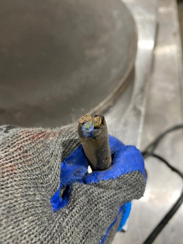 Commercial stainless steel electric countertop double crepe maker, model DE2, 110V. Close-up of a gloved hand inspecting wiring.
