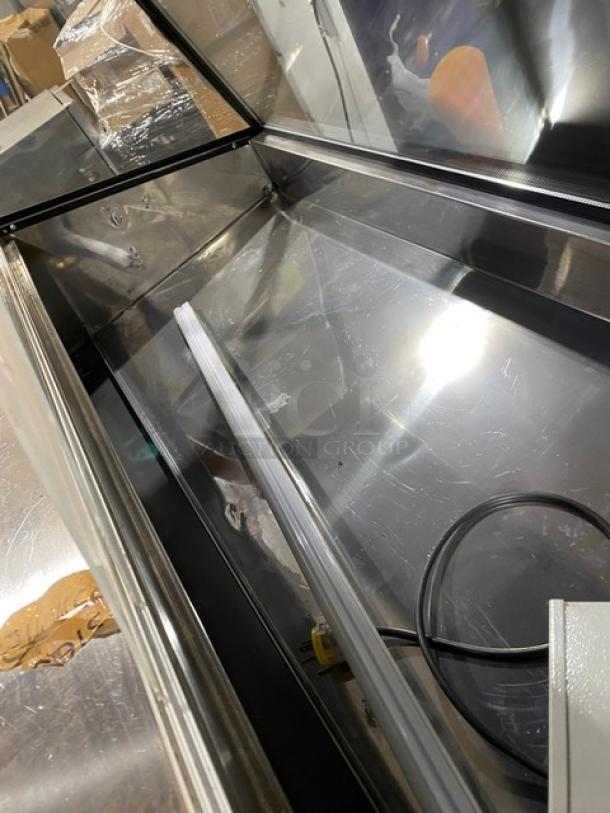 Commercial 60" black slanted glass refrigerated display case with wood-slatted base, rear prep area, and overstock storage.