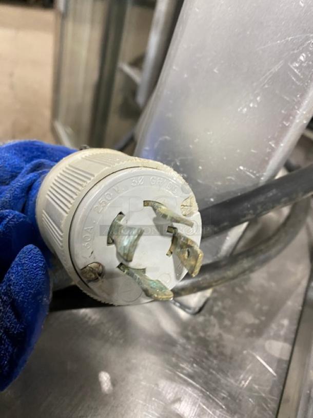 Butcher Boy B16 meat band saw plug, 208V, 3-phase connector shown with wear, blue glove holding plug.