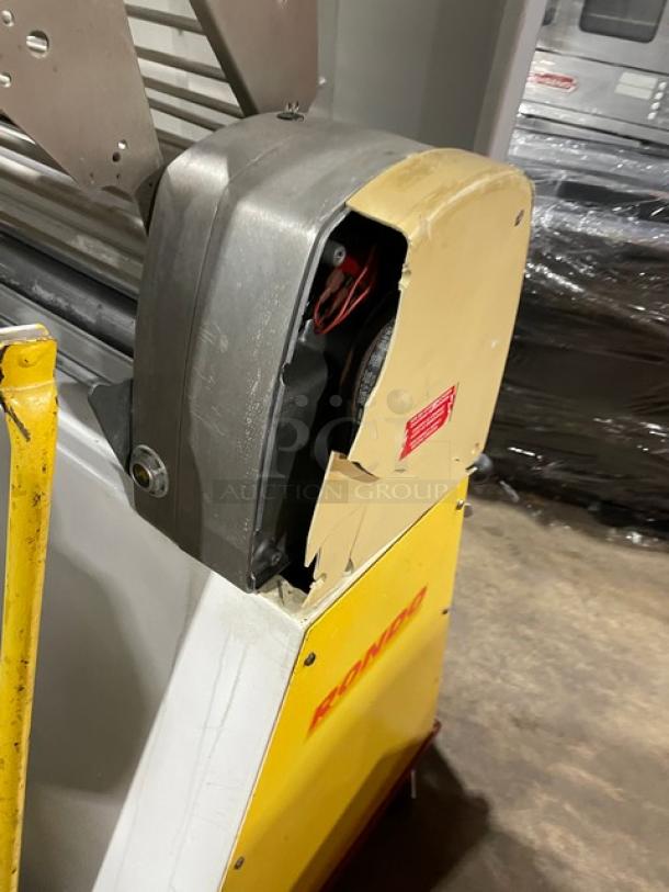 Seewer Rondo SS064C yellow electric dough sheeter with fold-up conveyor belt. Visible damage on the casing. Model: SS064C, SN: A6019004.