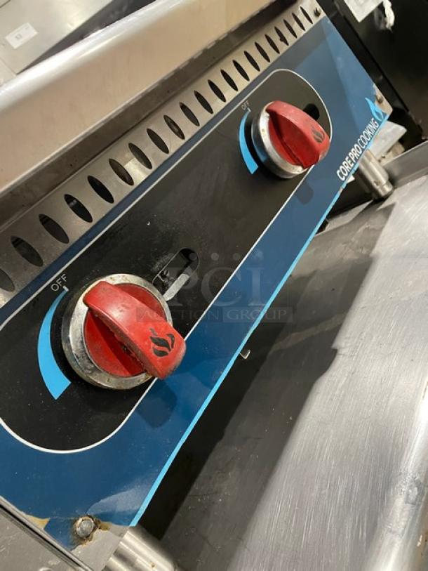 Core Pro Cooking 24" stainless steel griddle, model CPG24M, with red control knobs, back and side splash. Gas-powered.