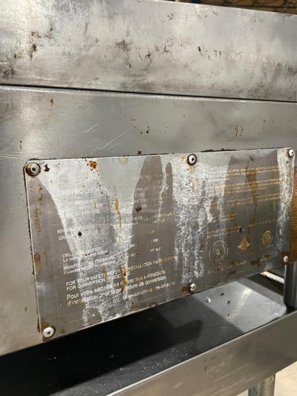 Core Pro Cooking 24" stainless steel flat griddle, Model CPG24M, on legs, with back and side splash, natural gas, visible wear.