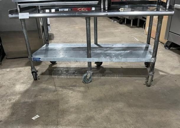 Sapphire stainless steel equipment stand with undershelf, up-turned back and side splash, on casters. Good condition.