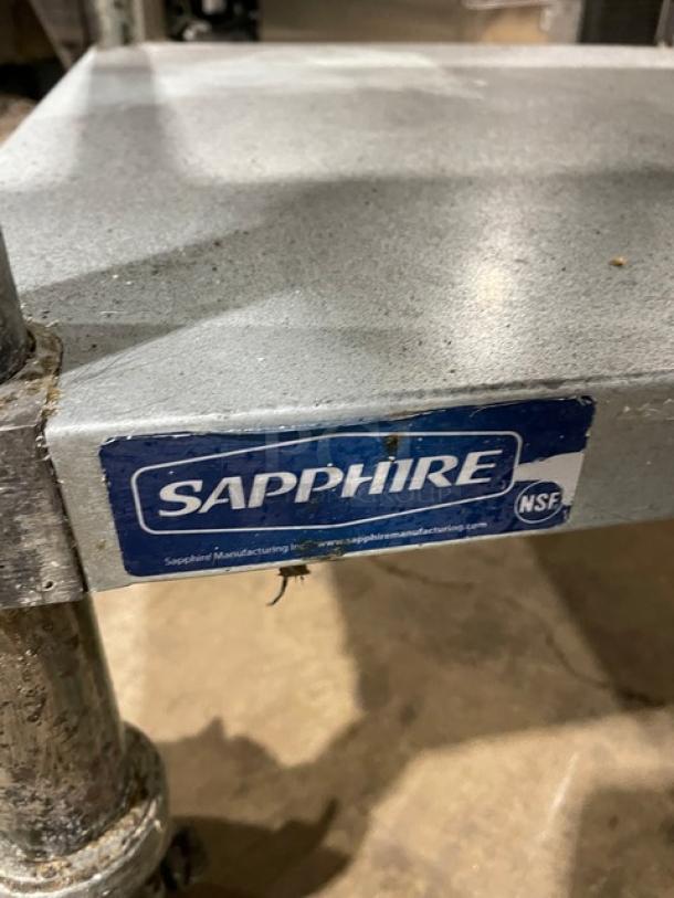 Sapphire stainless steel equipment stand with undershelf, up-turned splash edges, and casters. Label reads "Sapphire NSF."