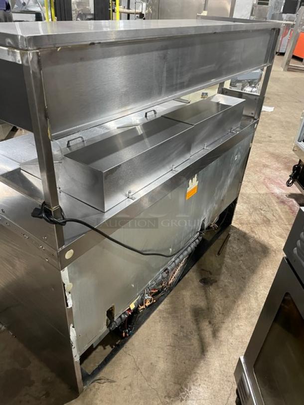 Delfield stainless steel 4-drawer refrigerated prep table, Model UCD4464N12DD5, with dual storage compartment. Signs of use.