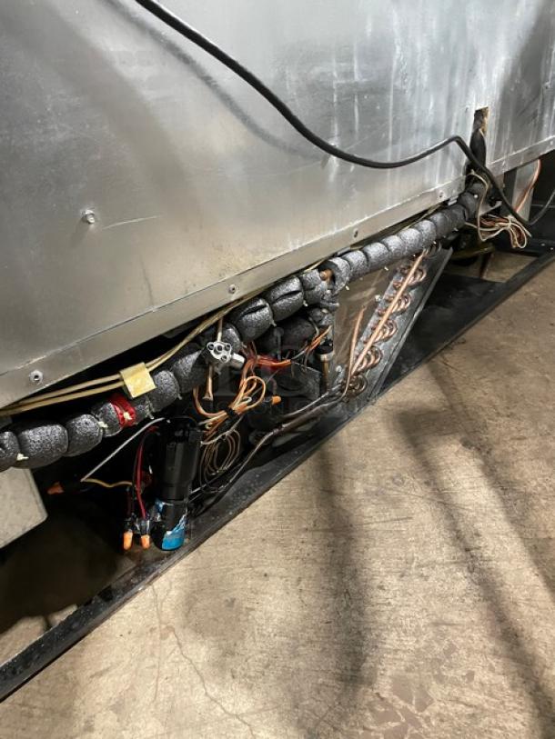 Delfield refrigerated prep table, model UCD4464N12DD5, shown from underside with exposed wiring and insulation.