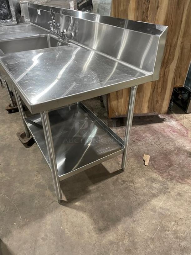 Custom stainless steel single compartment sink worktop with backsplash, swivel spout faucet, dual-sided shelf, on legs.