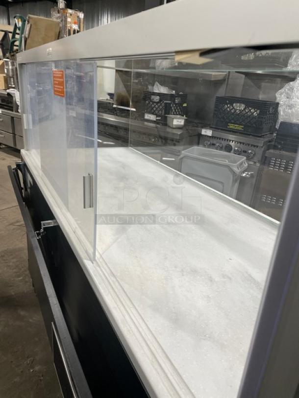 Structural Concepts SBZ6652DR refrigerated open grab-n-go merchandiser with enclosed glass top, sliding rear doors, and on legs.