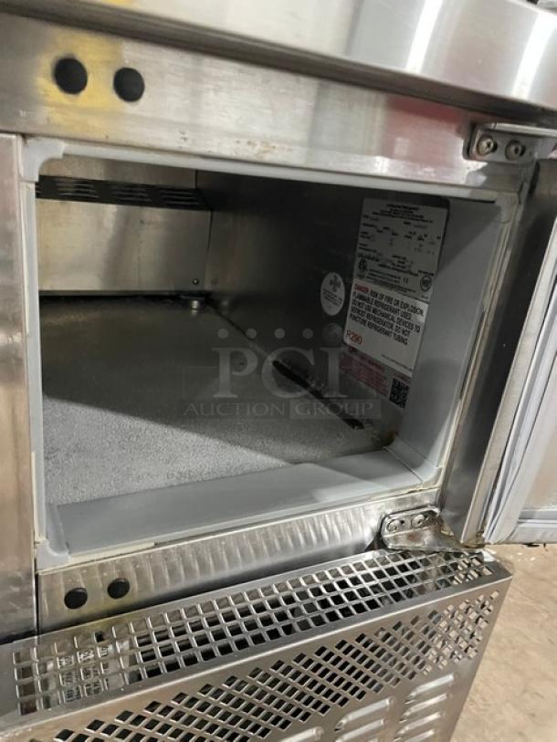 Continental Model RA68NB refrigerated prep table interior, stainless steel, with label showing specs. Includes poly coated rack.