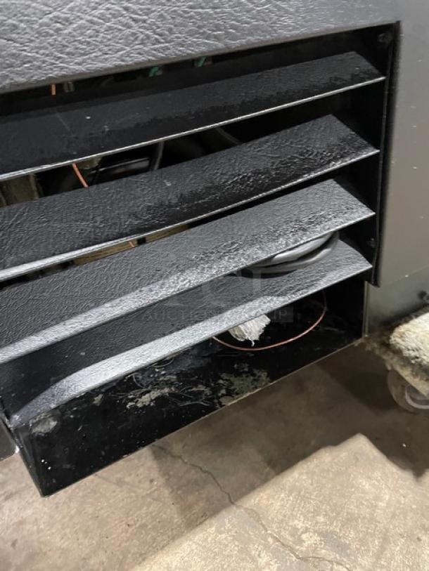 True TD-50-18 commercial bottle cooler vent detail, showing black exterior and forced-air system. Model and SN visible.