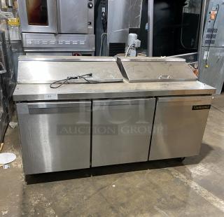 Continental 3-door stainless steel refrigerated prep table, Model SW7218, with polly coated rack and casters, good condition.