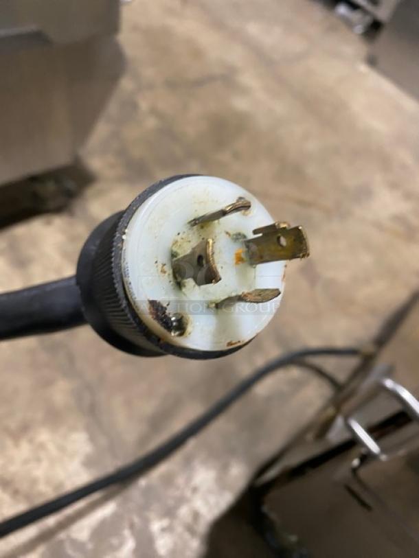 Close-up of the electric plug for a Taylor L811-23 griddle, showing its triple prong configuration.