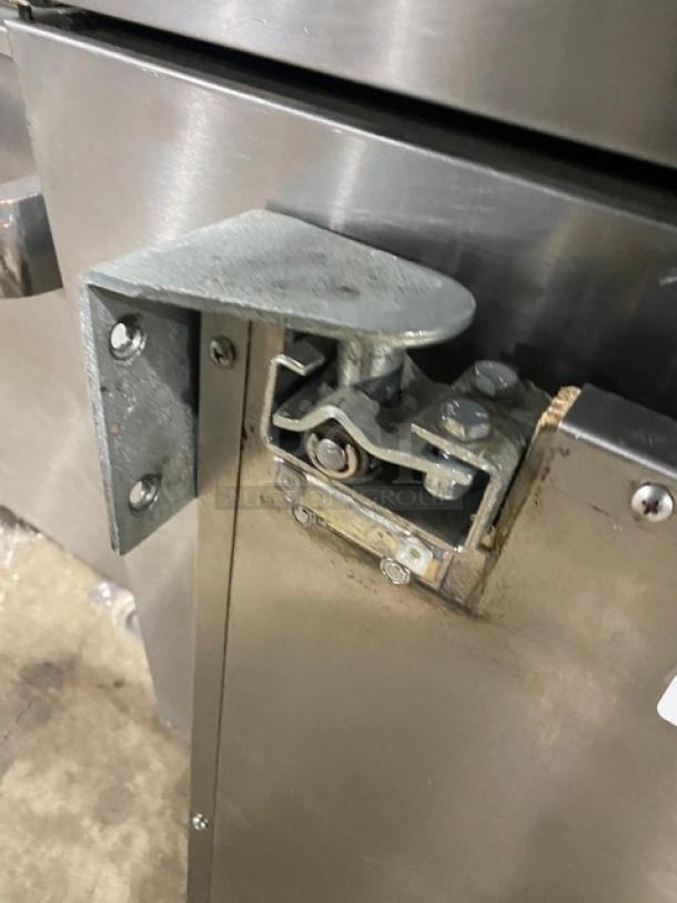 Commercial stainless steel single door with bracket and screws, showing hinge and fastening details. Solid, durable condition.