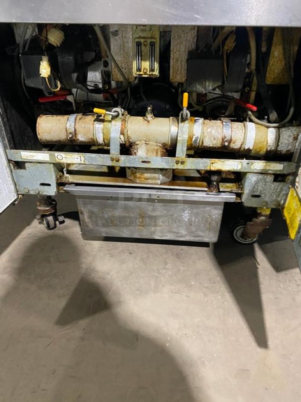 Frymaster 4-bay deep fat fryer system, model FMPH455SC. Features: digital control, oil filter, center dump, basket hangers. Natural gas, 110-120V, on casters. Visible wear on components.