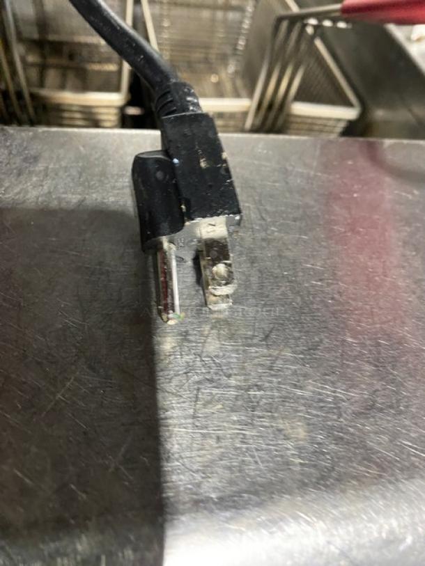 Frymaster FMPH455SC stainless steel 4-bay deep fryer system. Features center dump station, backsplash, basket hangers, digital control, oil filter.