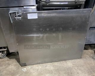 Commercial stainless steel single door with bracket and screws; robust, slightly used condition, ideal for kitchen equipment.