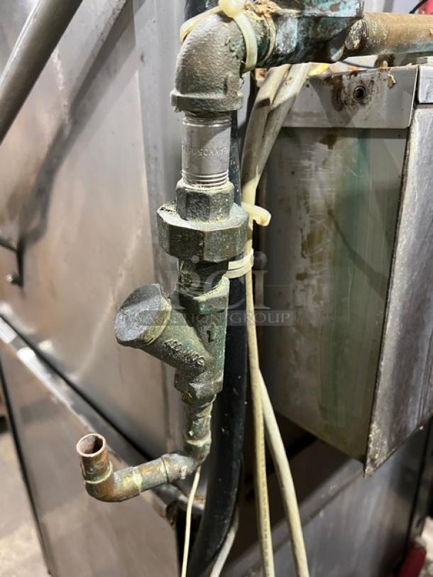 Hobart Advansys commercial dishwashing machine, stainless steel, visible pipes, used condition, mounted on legs.