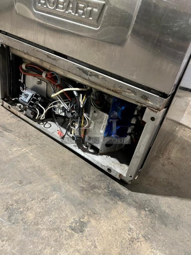 Hobart LXEH commercial undercounter dishwasher, stainless steel exterior, exposed internal wiring, model number visible.