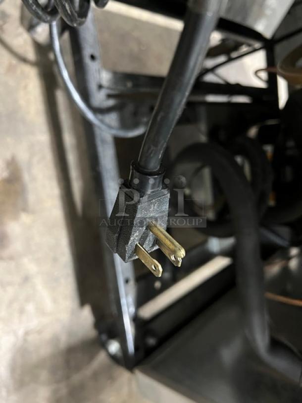 Close-up of a plug from a True Commercial Stainless Steel Single Door Freezer, Model T-23F, 115V 1 Phase, on casters.