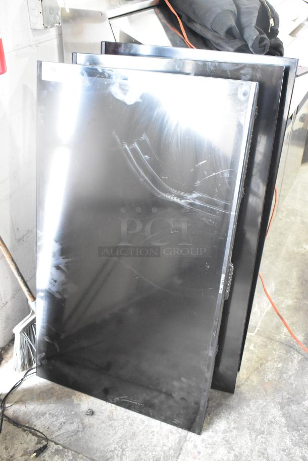 Three televisions, including a Sceptre, stacked against a wall. Condition shows wear with visible smudges. Buyer pickup only.