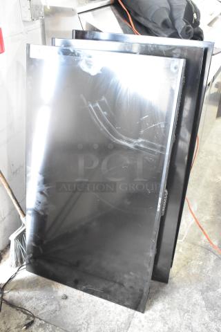 Three televisions, including a Sceptre, stacked against a wall. Condition shows wear with visible smudges. Buyer pickup only.