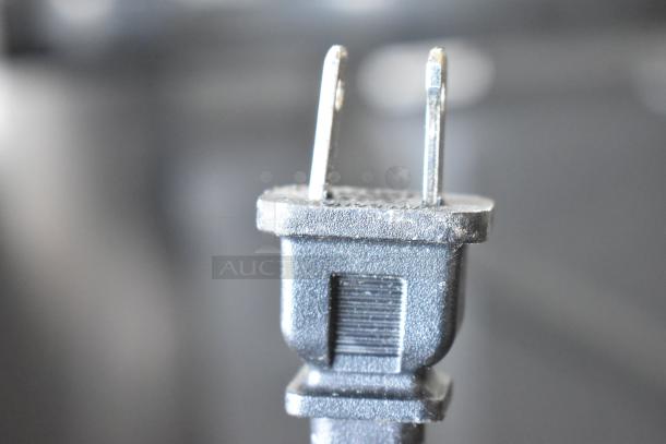 Close-up of a two-pronged electrical plug belonging to a set of three televisions including one Sceptre, available for pickup only.