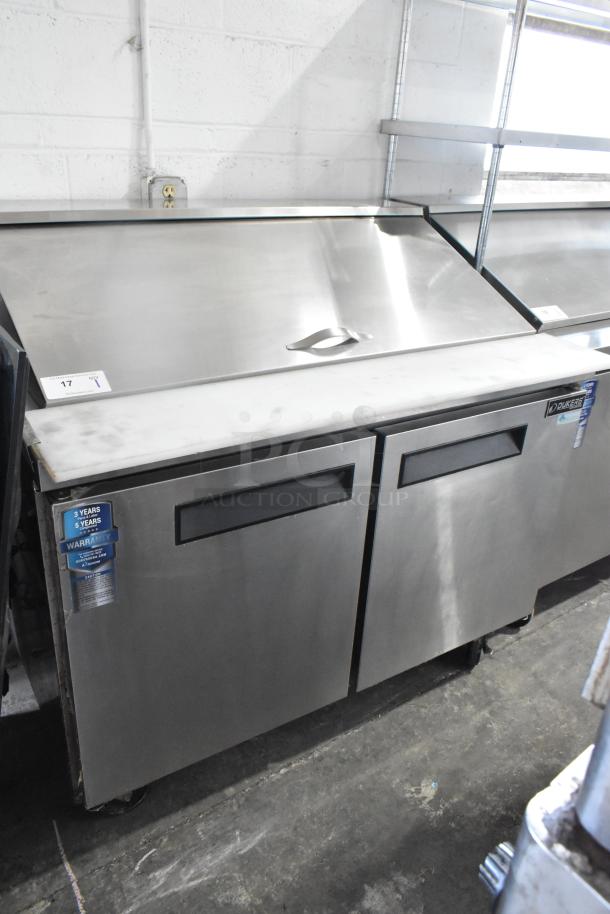 Dukers DSP48 sandwich salad prep table, stainless steel, commercial casters, 115V, like-new condition, warranty labels visible.