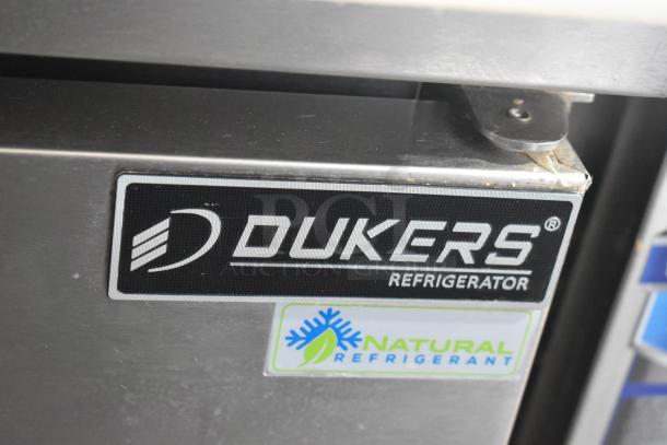 Dukers DSP48 Commercial Sandwich Prep Table with logo and "Natural Refrigerant" sticker, metal exterior, on casters.