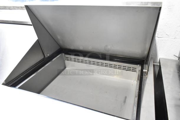 Dukers commercial sandwich salad prep table, 115 volts, 1 phase, open storage unit, clean stainless steel interior, on casters.