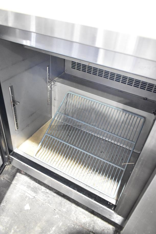 Dukers Commercial Prep Table with storage, open interior showing wire shelves, mega top, on casters, 115V, 1 Phase.