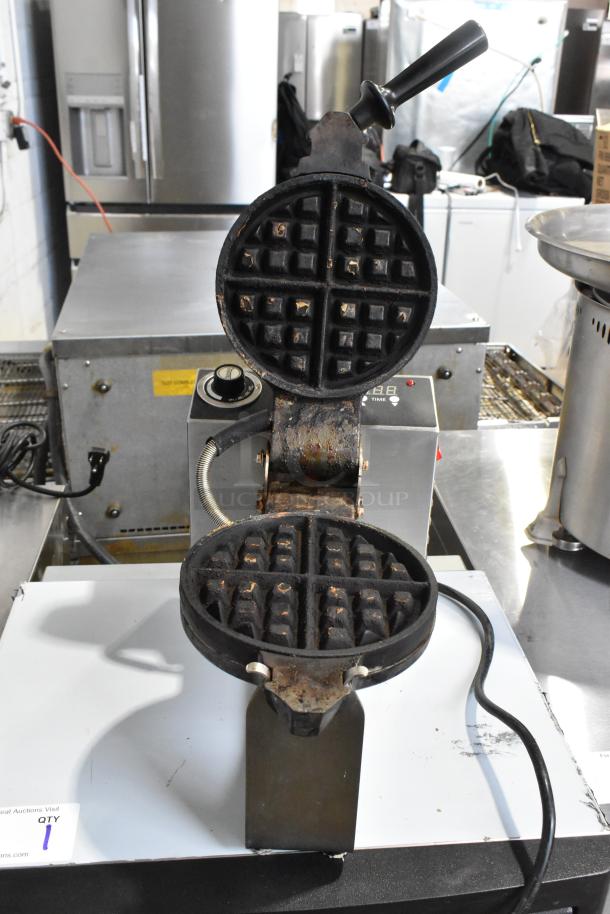 Sephra SEMANWB countertop waffle maker, 120V, 1 phase, black cast iron, visible wear, open waffle plates, control knob.
