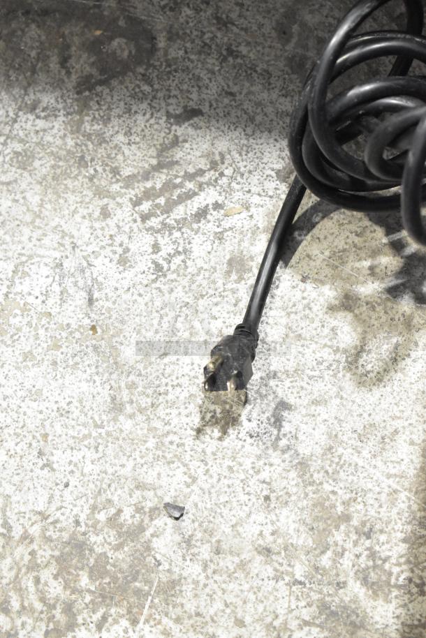 Coiled power cord of a Coldline UC-27F undercounter freezer, 115 volts, suitable for commercial use.