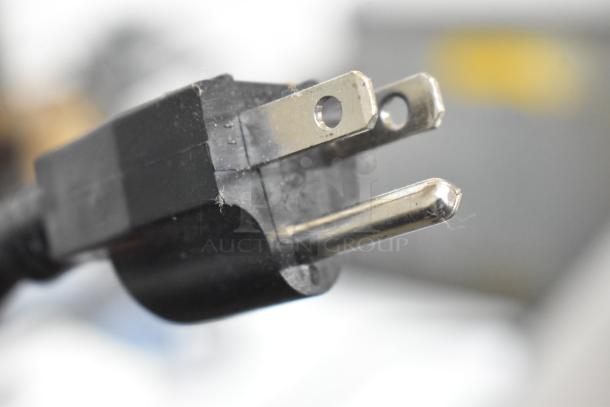 Close-up image of a power plug, likely part of the 2023 Sephra CF34/44 Cascade Chocolate Fountain, showing a standard 115V connection.