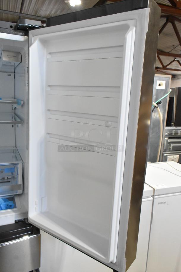 Frigidaire GRMS2773AF03 26.3 cu. ft. French door refrigerator with open freezer door, stainless steel finish.
